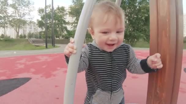 Mamá con el niño en el carrusel — Vídeo de stock