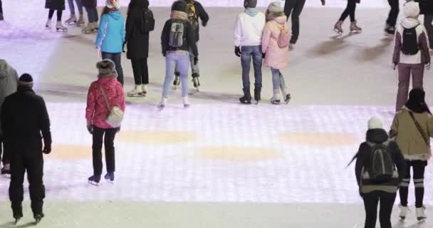 Visitantes de pista de patinaje y decoración de escenario y Navidad en el fondo — Vídeo de stock