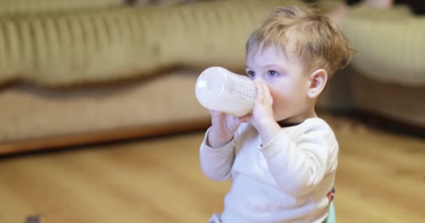 Garçon regarde la télévision et mange du lait — Video