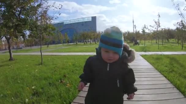 Spädbarn pojke på en trä gångväg — Stockvideo