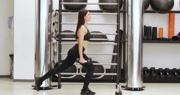 Beautiful girl lifts dumbbells — Stock Video