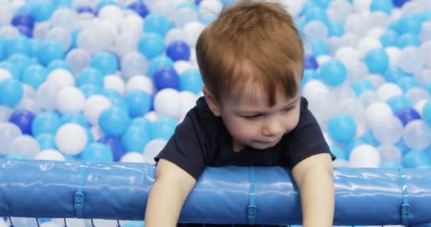 Infant boy plays on a plastic slide — Stok video