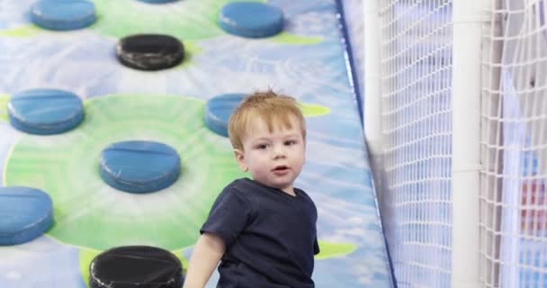 Infant boy plays on a plastic slide — ストック動画