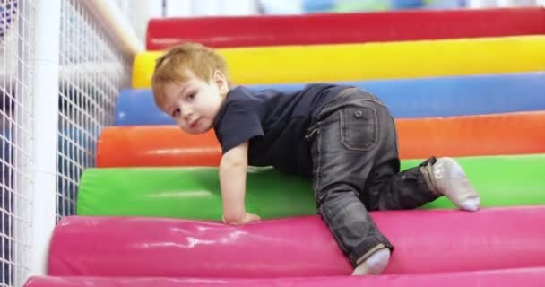 Niño juega en una diapositiva de plástico — Vídeos de Stock