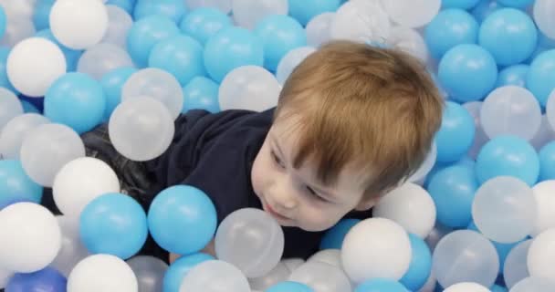 Infant boy plays on a plastic slide — Stock video