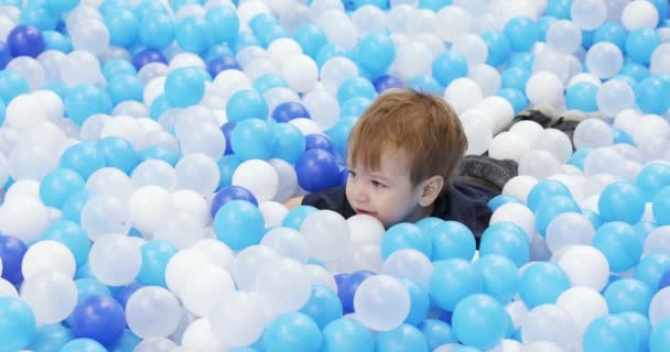 Infant boy plays on a plastic slide — Stockvideo