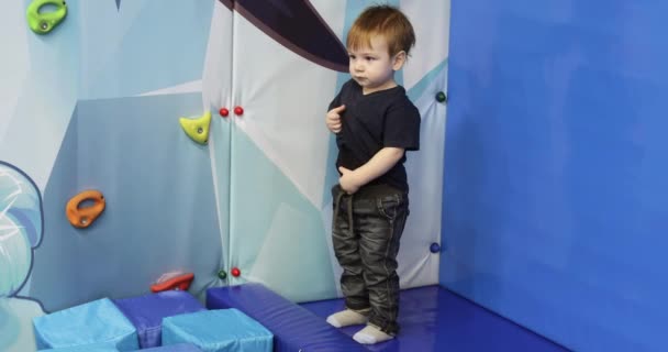 Boy watches children in a soft pool — Stockvideo