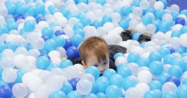 Infant boy plays on a plastic slide