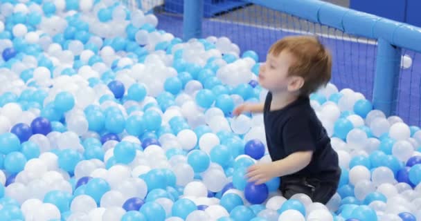 Infant boy plays on a plastic slide — 图库视频影像