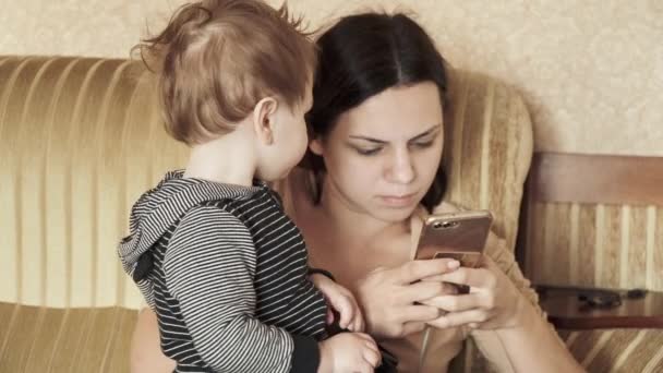 赤ちゃん男の子とともにお母さんオンザカウチ — ストック動画
