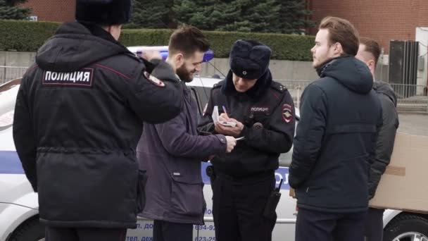 Policie přebírá údaje o pasech od účastníka jedné hlídky na Rudém náměstí — Stock video