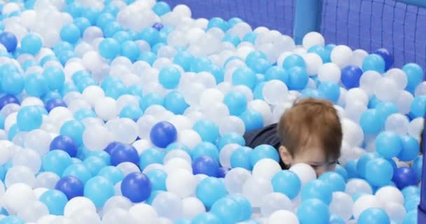 Infant boy plays on a plastic slide — Stock videók