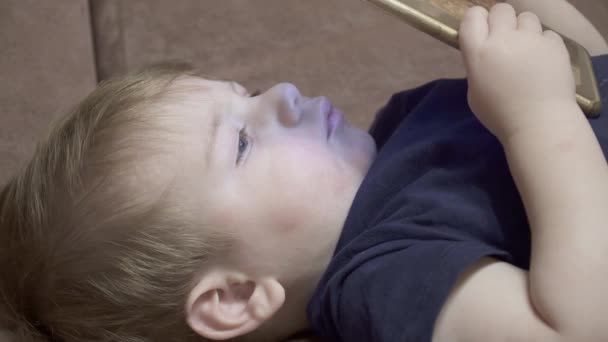 Niño viendo un vídeo en su teléfono — Vídeos de Stock