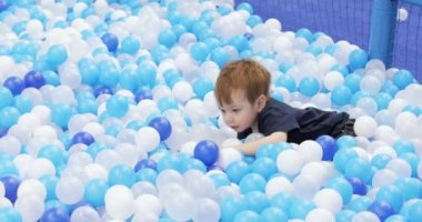 Infant boy plays on a plastic slide
