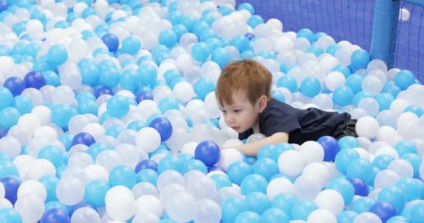 Infant boy plays on a plastic slide — Stockvideo