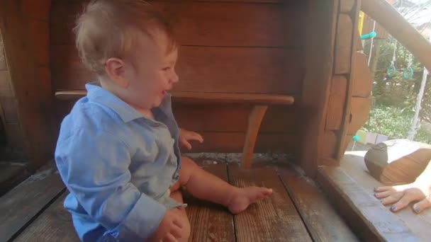 Niño en una casa de madera — Vídeos de Stock
