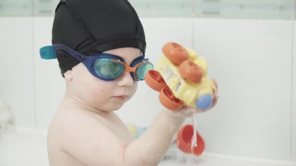 Junge in einem Bad in einer Mütze — Stockvideo
