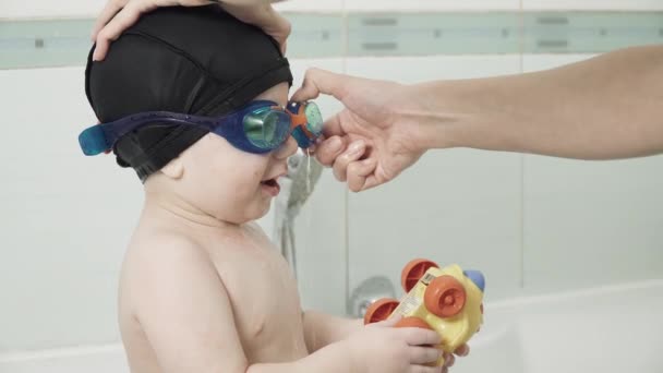 Bébé garçon dans un bain dans une casquette — Video
