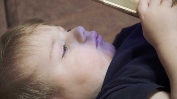 Menino assistindo um vídeo em seu telefone — Vídeo de Stock