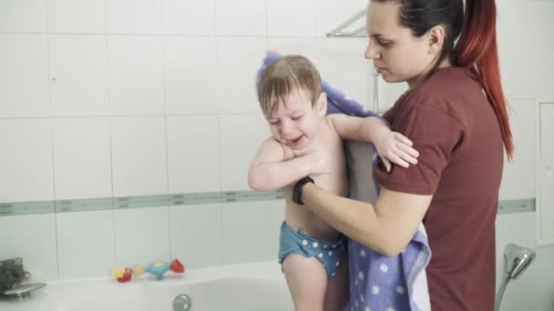 Moeder wikkelt haar zoon met een handdoek — Stockvideo