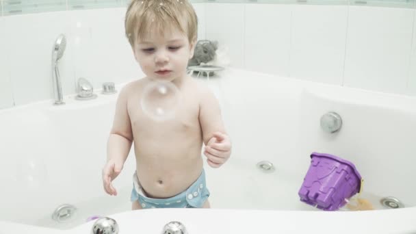 Miminko chlapec chytí mýdlové bubliny — Stock video