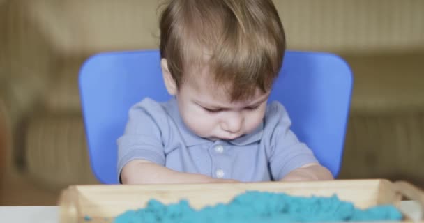 Niño juega artificial azul — Vídeos de Stock