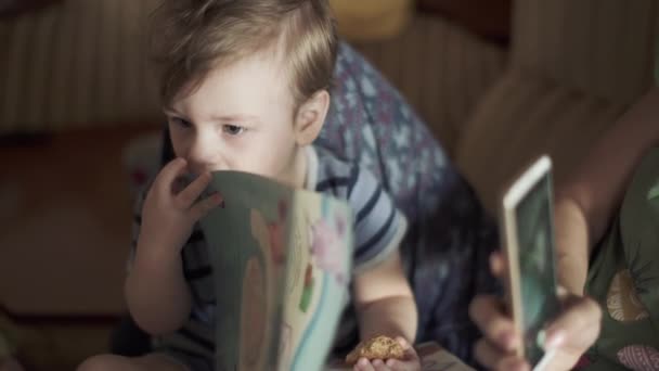 Junge mit Rotz liest ein Buch — Stockvideo