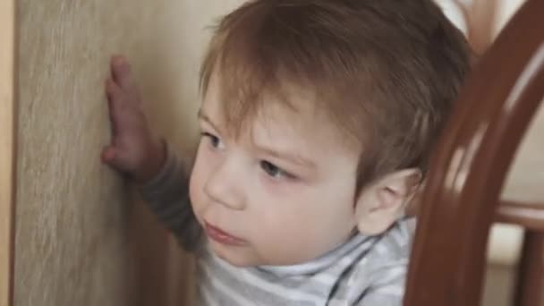 Kleine jongen gluurt de deur uit — Stockvideo