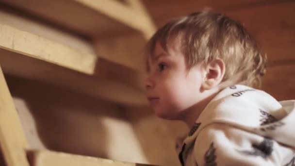 Мальчик в пижаме лазает — стоковое видео