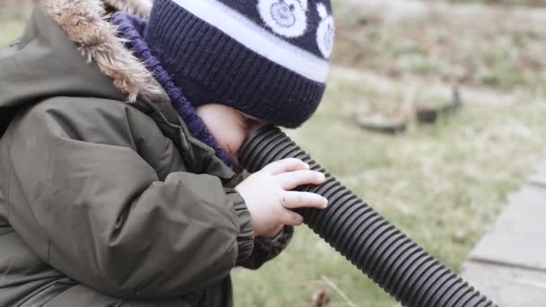 Niño en overol juega con un corrugado — Vídeo de stock
