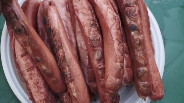 Hot smoked sausages in plastic dishes — Stock Video