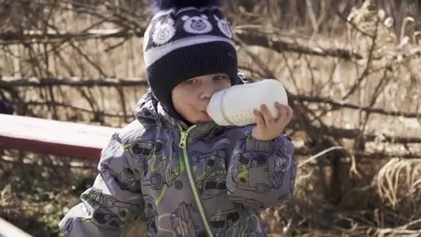 Jongen eet melk uit een fles — Stockvideo