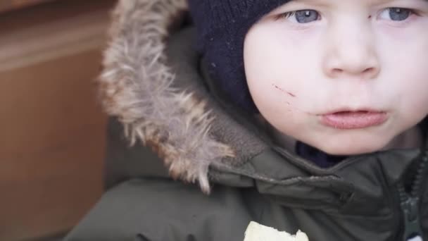 Niño en overoles come papas fritas — Vídeos de Stock