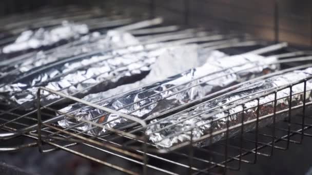 Comida para peces en papel aluminio en el fuego — Vídeo de stock