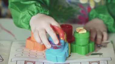 Masadaki çocuk çiziyor.