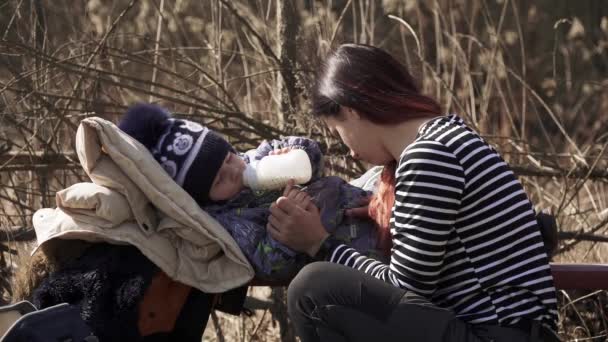 Мама кормит ребенка на улице — стоковое видео