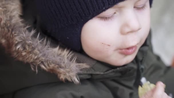 Niño en overoles come papas fritas — Vídeo de stock