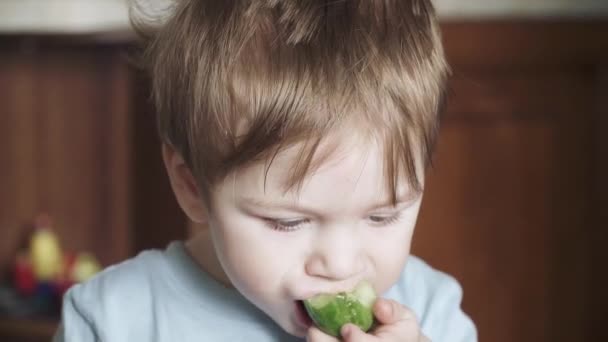 Un garçon mange un concombre — Video