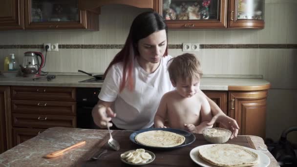 Ребенок с мамой делает торт — стоковое видео