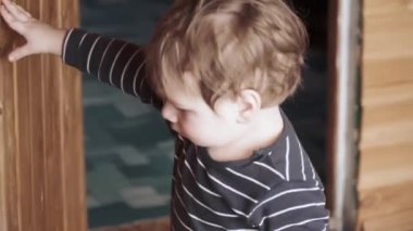 Çocuk ahşap kapıyı kapatıyor.
