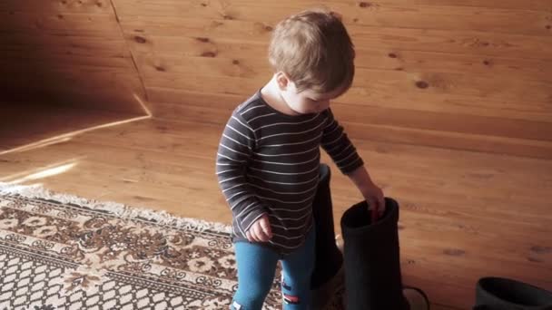Niño juega con botas de lana — Vídeo de stock