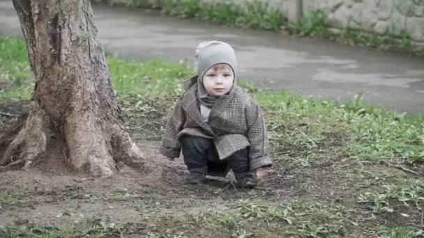 Niño en un abrigo en el callejón — Vídeos de Stock