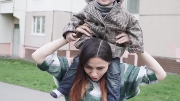 Gyermek egy kabátban anyán. — Stock videók