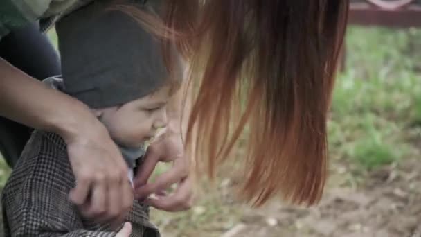 Niño en un abrigo ajustar la ropa — Vídeos de Stock