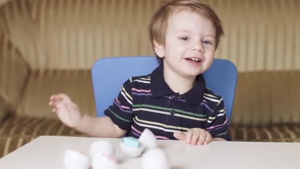 Menino criança joga um quebra-cabeça — Vídeo de Stock