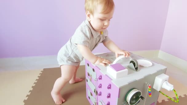 Baby spielt mit geschäftigem Würfel — Stockvideo