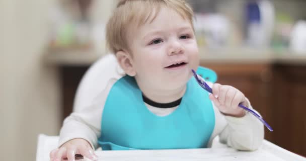 Bambino ragazzo mangia con un cucchiaio — Video Stock