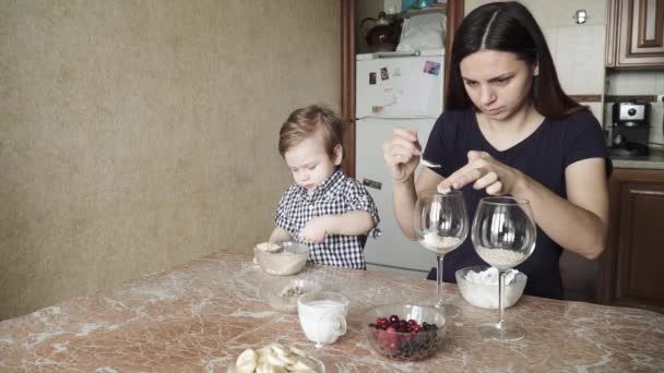 Oğlan çocuğu anneye hazırlıkta yardım ediyor. — Stok video