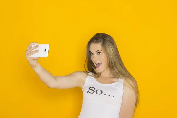 Mujer atractiva joven hacer selfie en su teléfono inteligente — Foto de Stock