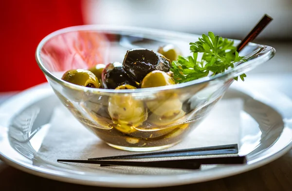 Plaka üzerinde cam kapta zeytin çeşitleri